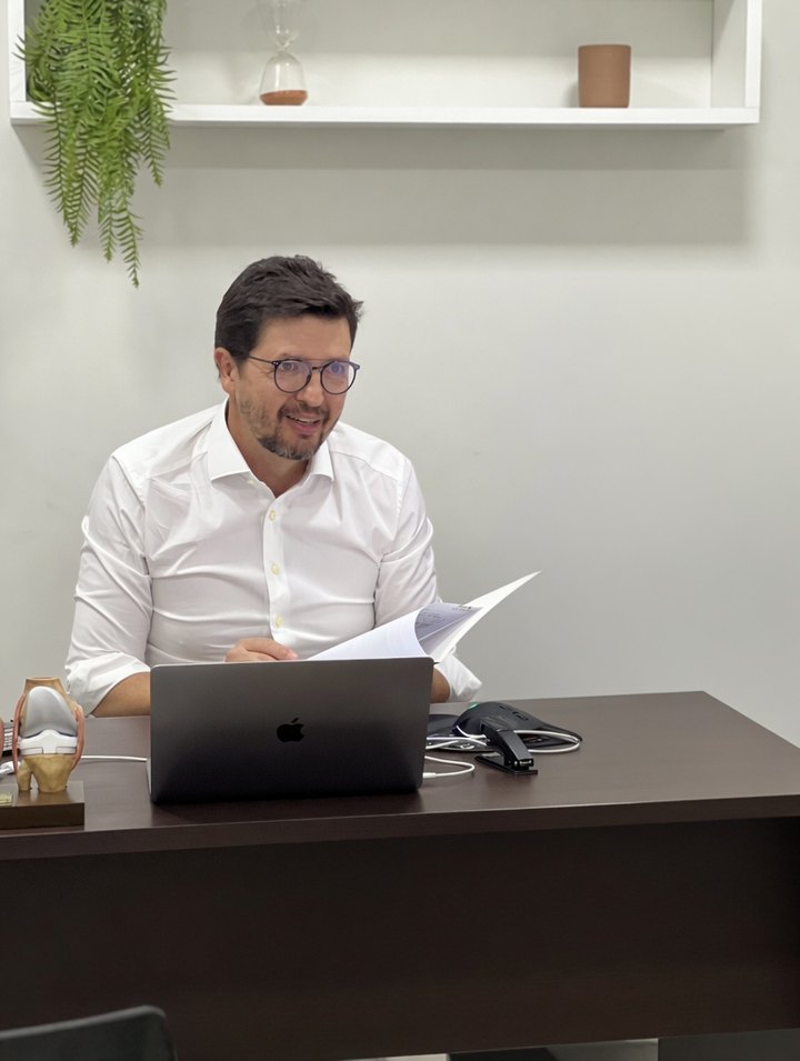 Dr. Frederico Jaña em consultório, analisando exames